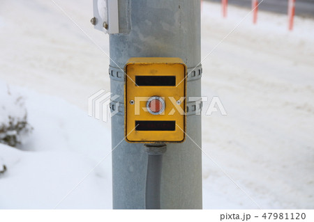 押しボタン式信号機の押しボタン箱。背景は積雪のある道路。 押しボタン式信号機の押しボタン箱。背景は積雪のある道路。 47981120