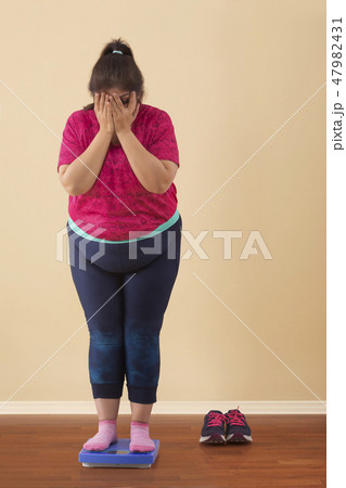 Woman Standing On Measuring Scale 47982431