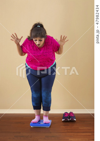 Overweight Woman Standing On Measuring Scale Overweight Woman Standing On Measuring Scale 47982434