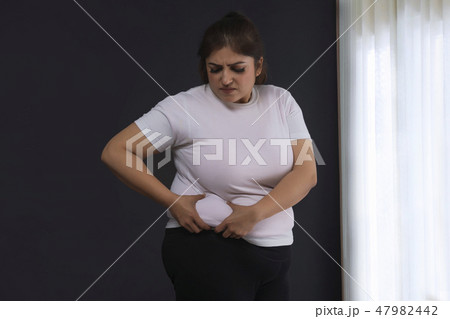 Woman Holding His Belly Fat With Both Hands 47982442