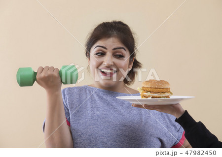 Woman Exercising Cropped Hand Giving Burger Woman Exercising Cropped Hand Giving Burger 47982450