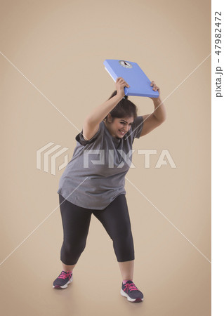 Woman Frustrated From Her Weight Throwing Scale Woman Frustrated From Her Weight Throwing Scale 47982472