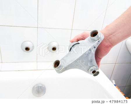 Plumber holding a dual outlet shower faucet 47984175