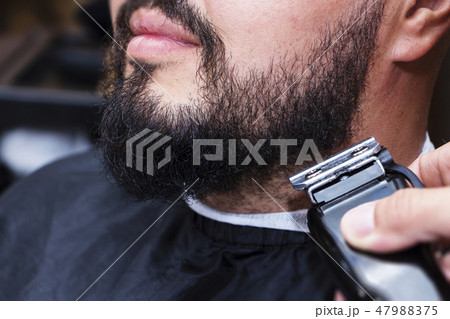 Beard styling and cut. Close up cropped photo Beard styling and cut. Close up cropped photo 47988375