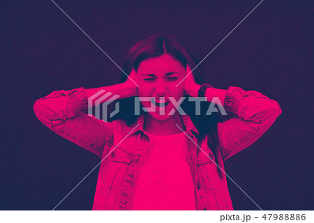 The girl, loudly, closed her ears with her hands duotone 47988886