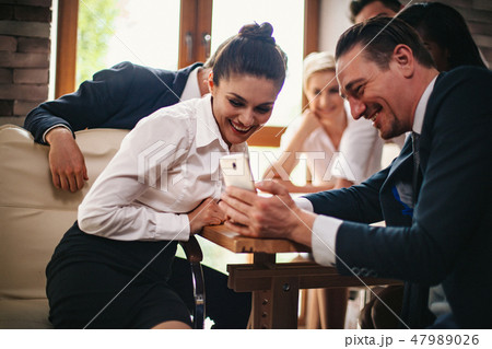 Young businesswoman looks at her colleague's phone 47989026