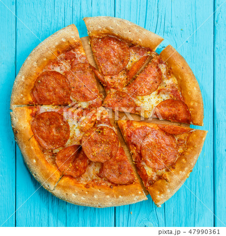 Pizza on a blue wooden table. 47990361