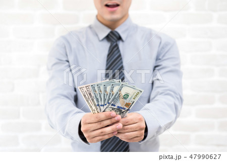 Businessman showing US dollar money on hand 47990627