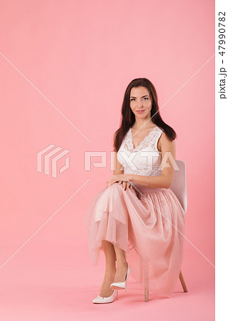 charming woman in pink lush skirt on pink background. charming woman in pink lush skirt on pink background. 47990782