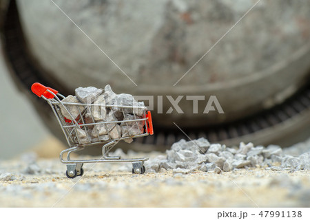 Shopping trolley stands on the pile of stone Shopping trolley stands on the pile of stone 47991138