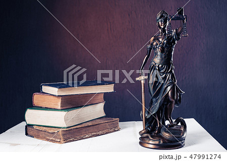 Themis figurine stands on a white wooden table Themis figurine stands on a white wooden table 47991274