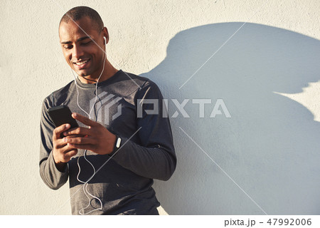 Relaxing after workout. Close up portrait of cheerful african athlete taking a break and chatting Relaxing after workout. Close up portrait of cheerful african athlete taking a break and chatting 47992006