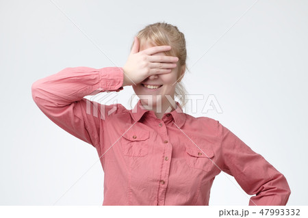 Funny portrait of smiling blonde girl close her eyes with her hands, waiting for gift. Funny portrait of smiling blonde girl close her eyes with her hands, waiting for gift. 47993332