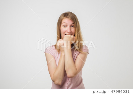 Shocked european slim woman biting her fist in fear 47994031