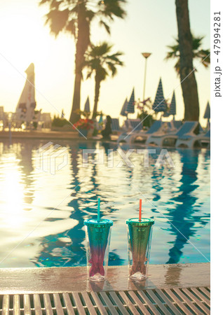 beach holidays background with two cocktails In mermaid tail glass near swimming pool 47994281