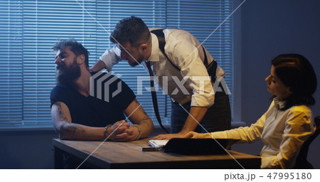 Violent policeman interrogating criminal about drugs 47995180