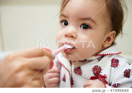 Portrait of baby brushing teeth 47996689