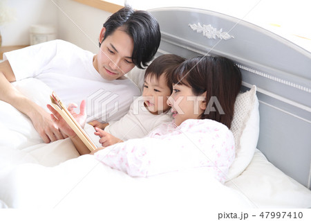 ベッドに入る若い家族 47997410