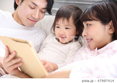 ベッドに入る若い家族 47997414