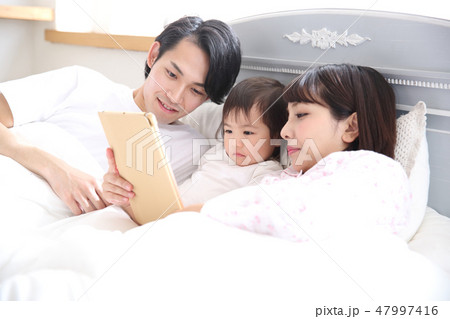 ベッドに入る若い家族 47997416