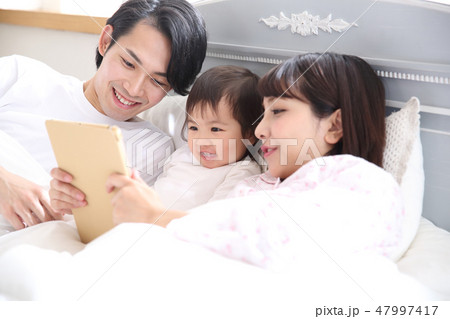 ベッドに入る若い家族 47997417