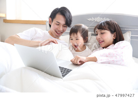 ベッドに入る若い家族 47997427