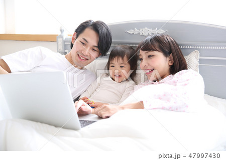 ベッドに入る若い家族 47997430