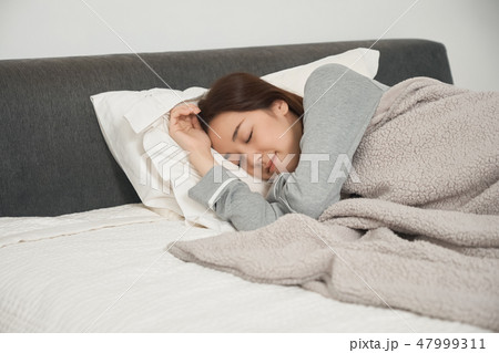 ベッドで寝ている女性 ベッドで寝ている女性 47999311