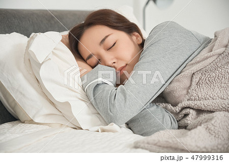 ベッドで寝ている女性の写真素材