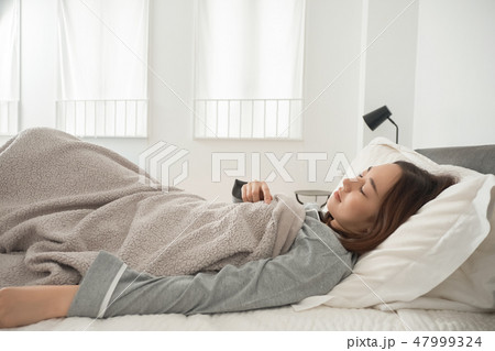 ベッドで寝ている女性 ベッドで寝ている女性 47999324