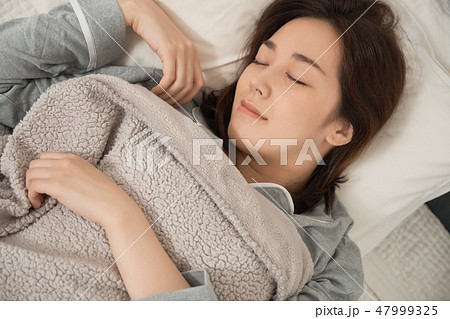 ベッドで寝ている女性 47999325