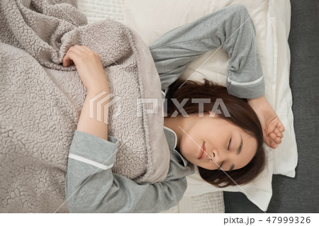 ベッドで寝ている女性 ベッドで寝ている女性 47999326