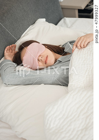 ベッドで寝ている女性 47999327