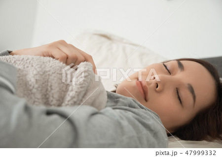 ベッドで寝ている女性 47999332