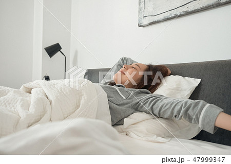 ベッドで目覚める女性 ベッドで目覚める女性 47999347