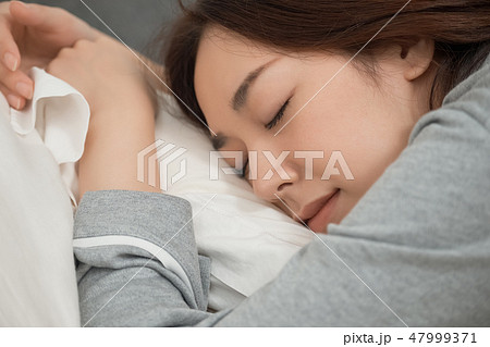 ベッドで寝ている女性 47999371