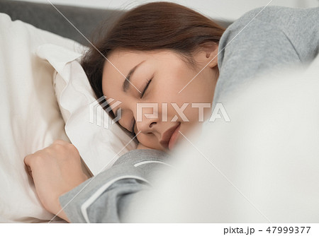 ベッドで寝ている女性 47999377