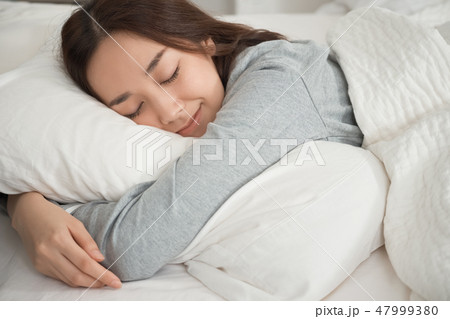 ベッドで寝ている女性 47999380