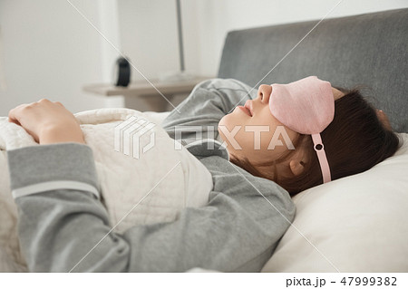 ベッドで寝ている女性 ベッドで寝ている女性 47999382