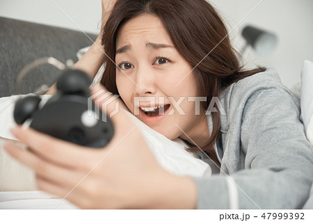 寝坊をして焦る女性 47999392