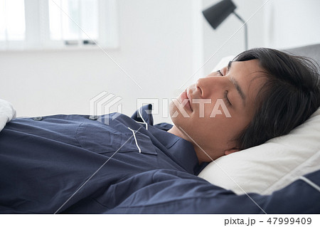 ベッドで寝ている男性 47999409