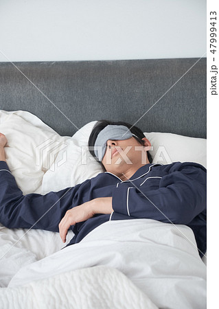 ベッドで寝ている男性 47999413