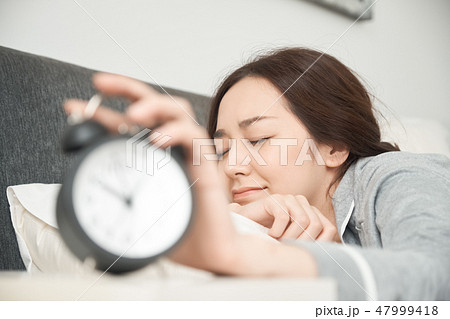 ベッドで目覚める女性 47999418