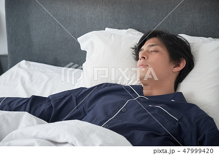 ベッドで寝ている男性の写真素材