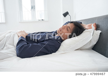 ベッドで寝ている男性 47999467