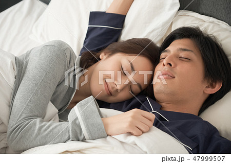ベッドで寝ている夫婦 ベッドで寝ている夫婦 47999507