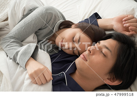 ベッドで寝ている夫婦 47999518