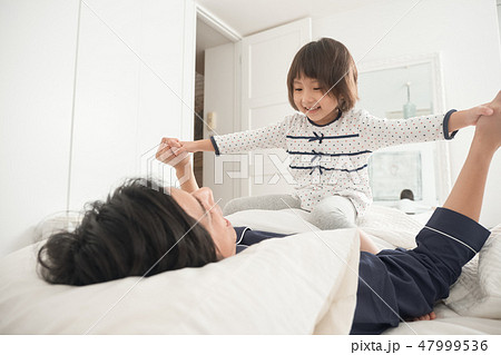 ベッドで遊ぶ親子 47999536