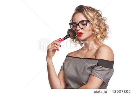 Portrait of female stylist standing with makeup brushes Portrait of female stylist standing with makeup brushes 48007806