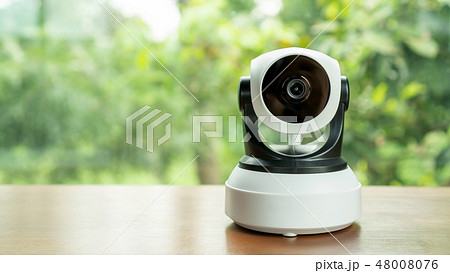 The security IP camera on a wooden table. 48008076